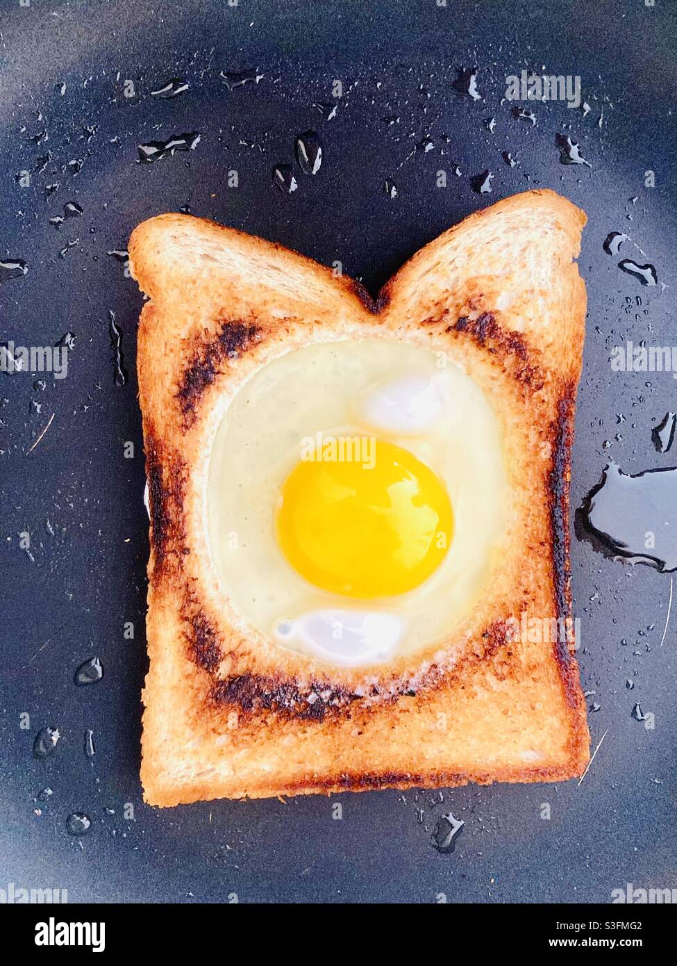 Kochen von Spiegelei in französischem Toast Stockfoto
