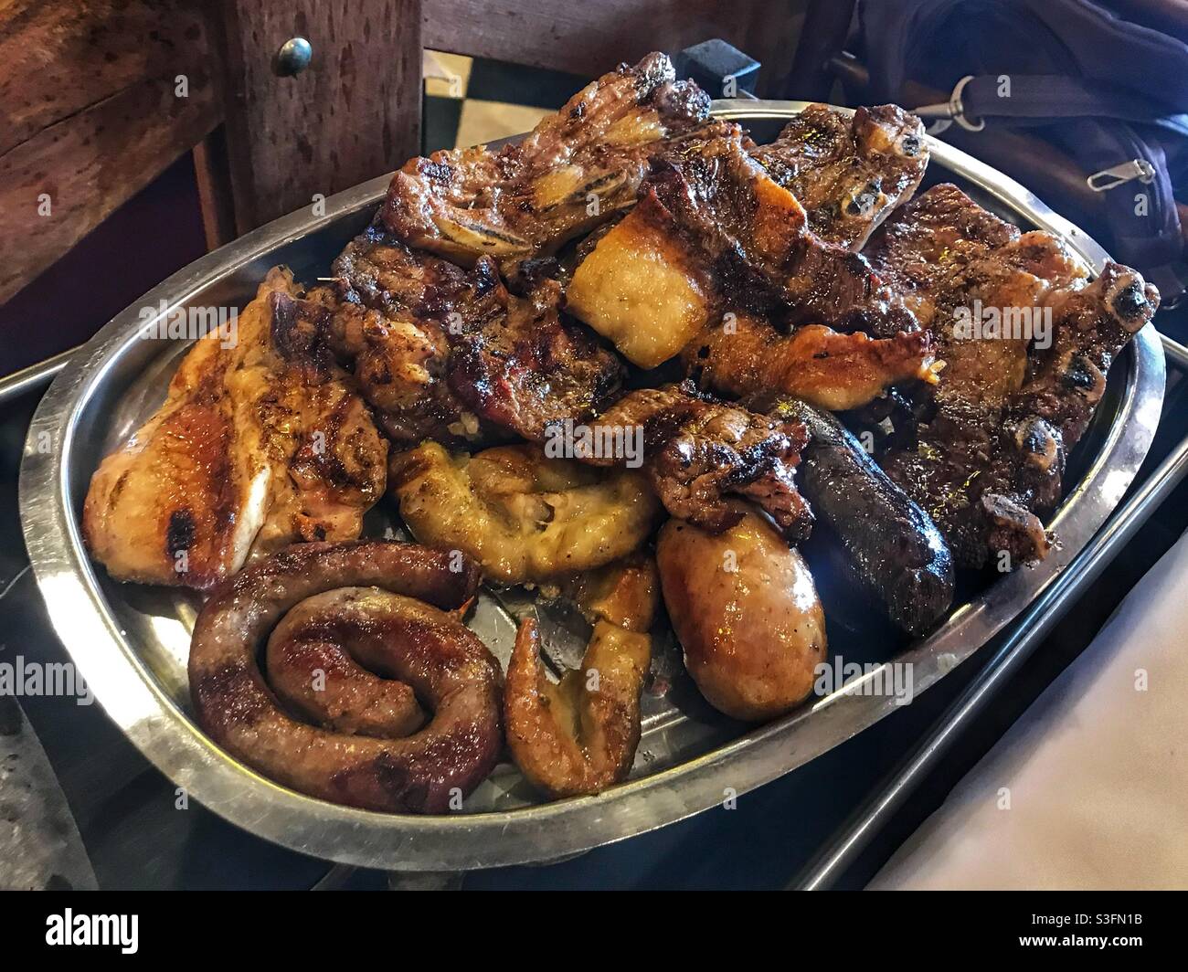 Ein Parrillada oder gemischter Grill mit verschiedenen Fleischsorten in Salta, Argentinien - Smartphone-aufgenommenes Stockfoto