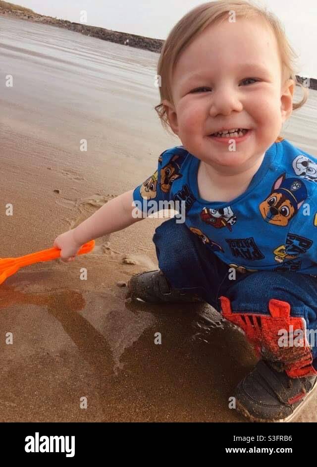 Fröhlicher Junge am Strand Stockfoto