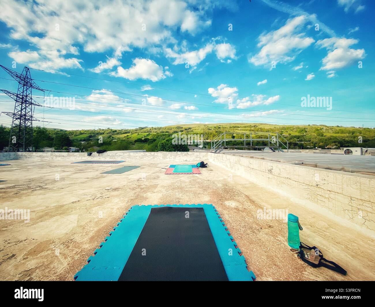 Ein Foto eines Yoga, das auf einem Gebäude aufgestellt wurde. Blick auf die Industrie auf dem Dach mit wunderschönem Himmel Stockfoto