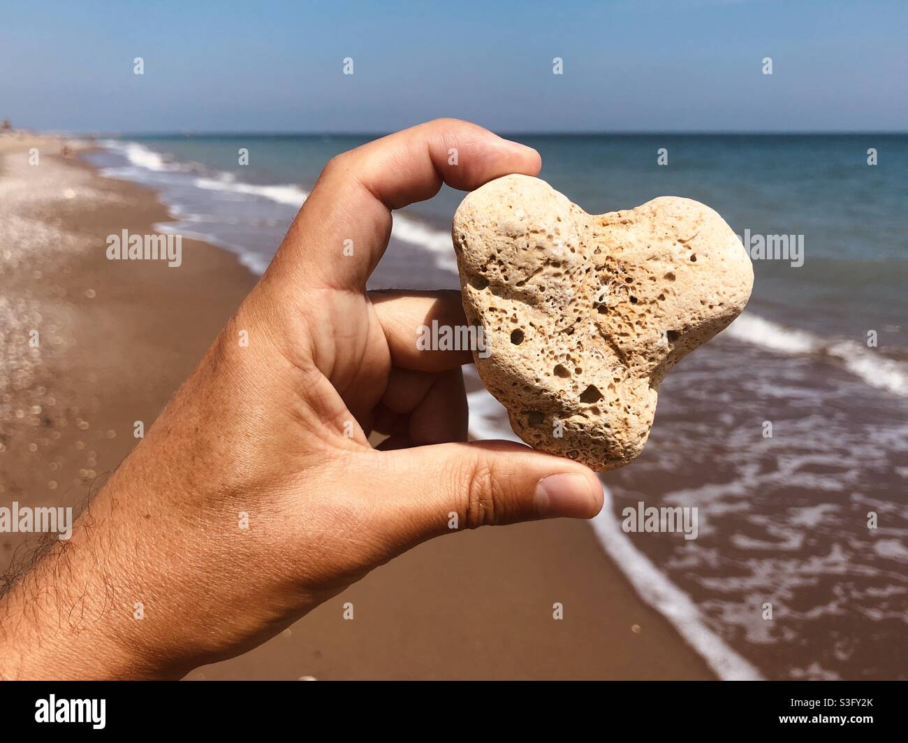 Herzförmiger Stein am Strand gefunden Stockfoto