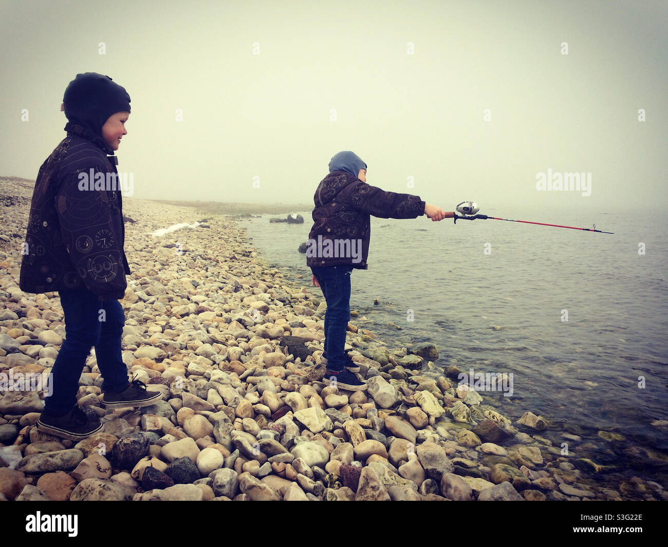 Jungs fischen am felsigen Strand in Hiiumaa, Estland Stockfoto