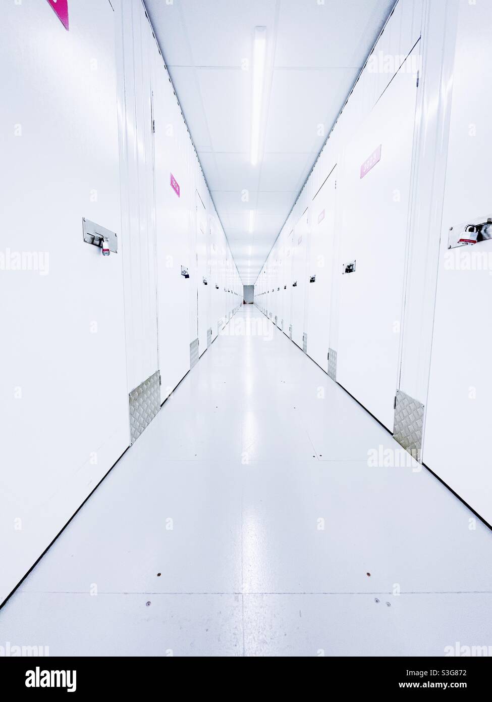 Langer, hell erleuchteter Korridor der Lagereinrichtung. Stockfoto