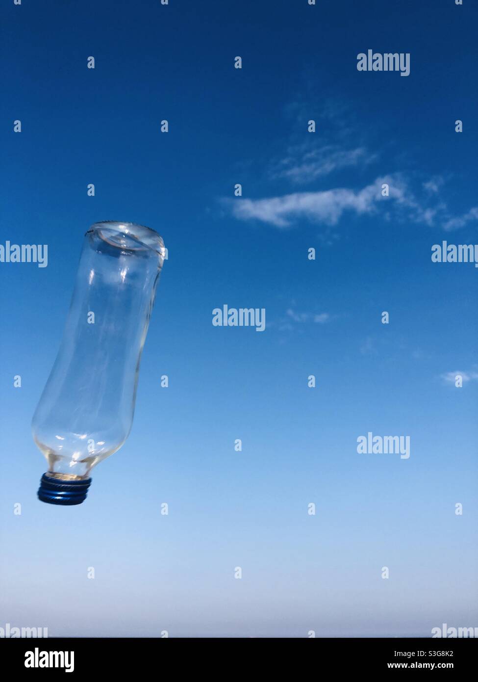 Klare Glasflasche in der Luft - Smartphone-aufgenommenes Stockfoto