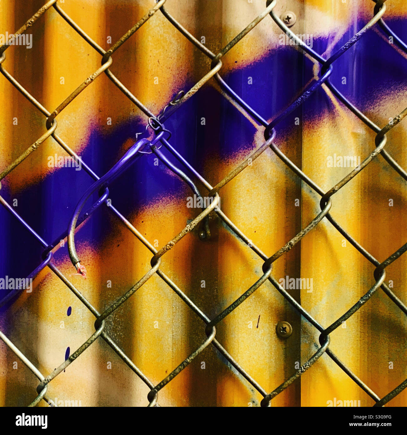 Kettengliederzaun vor der lackierten Oberfläche Stockfoto