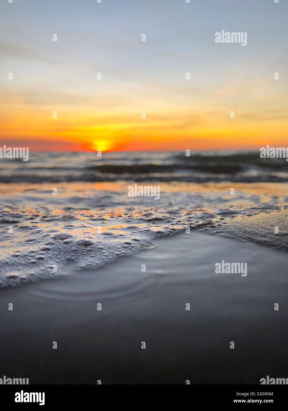 Sonnenuntergang über dem Meer am Strand - Smartphone-aufgenommenes Stockfoto