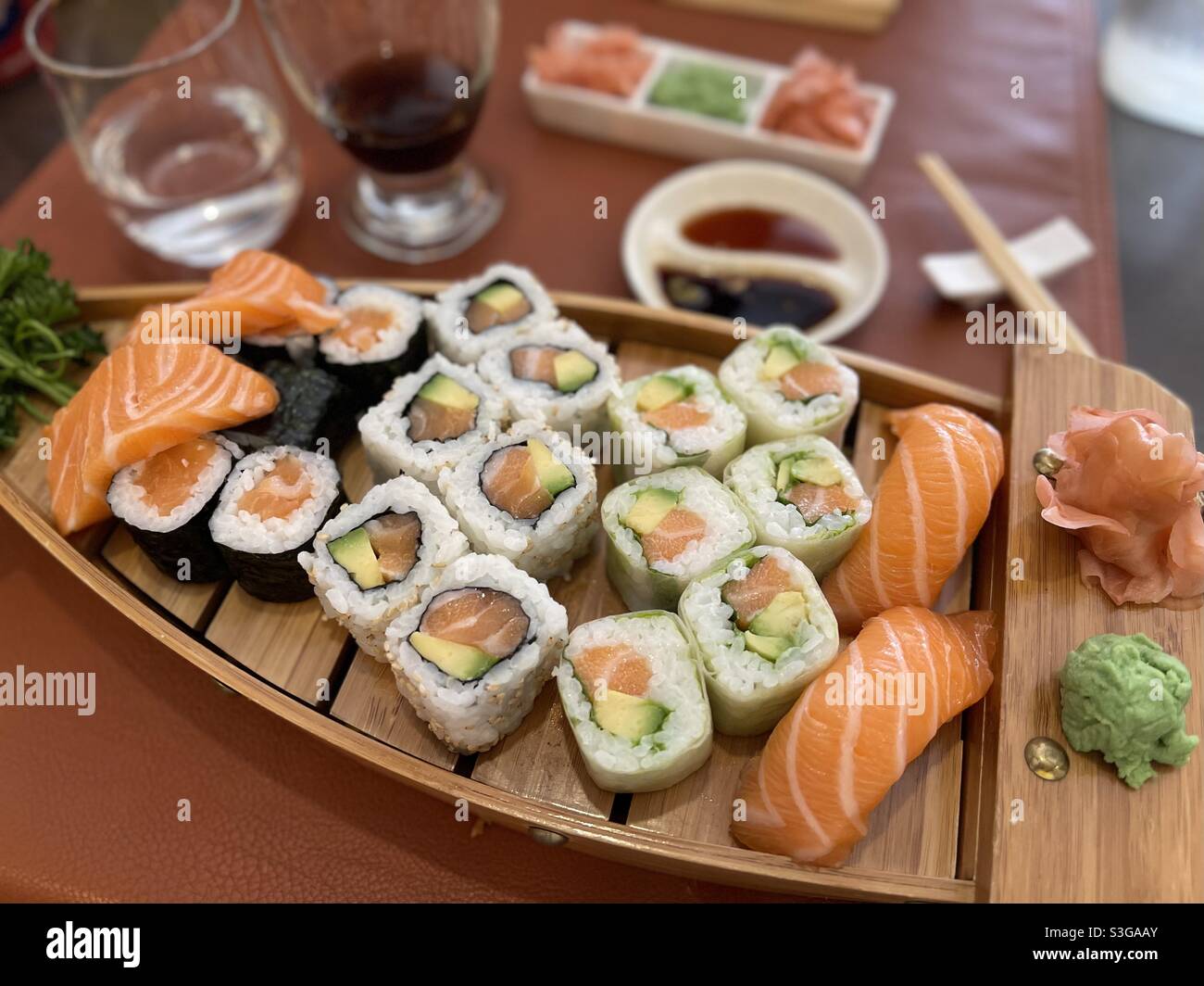 Sushi mit Lachs und Thunfisch auf einer hölzernen Bootsplatte in einem japanischen Restaurant in Martigues, in der Nähe von Marseille, Bouches-du-Rhône, Provence-Alpes-Côte d'Azur, Südfrankreich Stockfoto