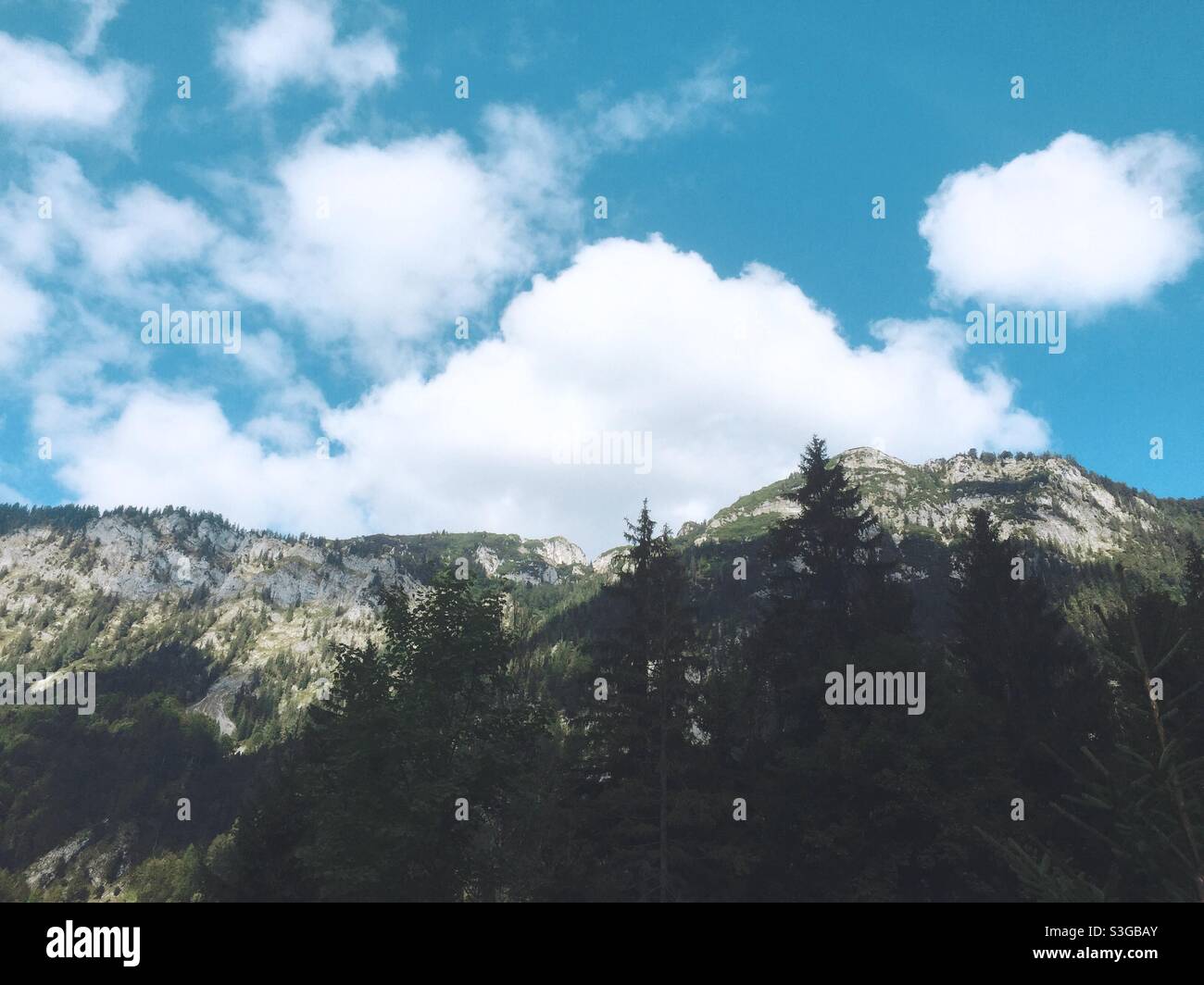 Blauer Himmel und weiße Wolken über einem Bergmassiv in den bayerischen Alpen in Deutschland Stockfoto