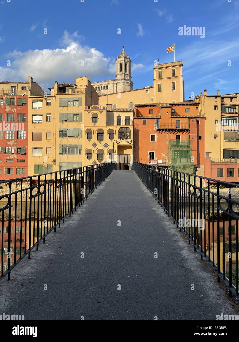 Fußgängerbrücke über den Fluss Onyar und historische Gebäude in Girona, Cataluña, Spanien. Stockfoto