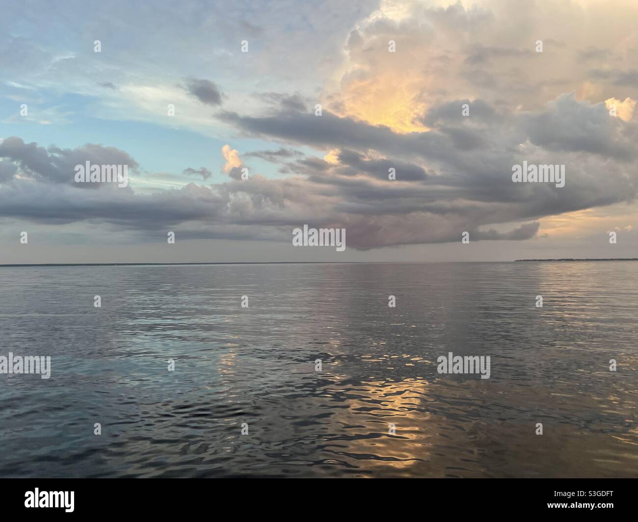 Wolkiger, weicher Sonnenuntergang am Wasser - Smartphone-aufgenommenes Stockfoto