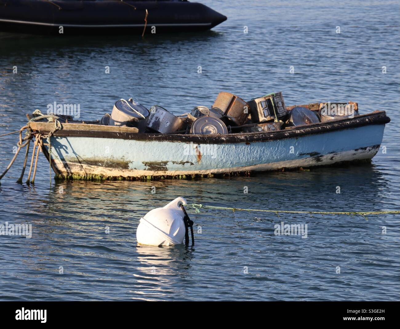 Ein Boot auf dem Meer, das voll von Waschmaschinen Trommeln innen ist Stockfoto