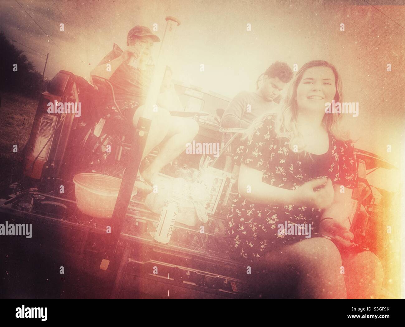 Vintage antiken Foto-Effekt von Menschen sitzen in der Rückseite eines Pickup-LKW - Smartphone-aufgenommenes Stockfoto