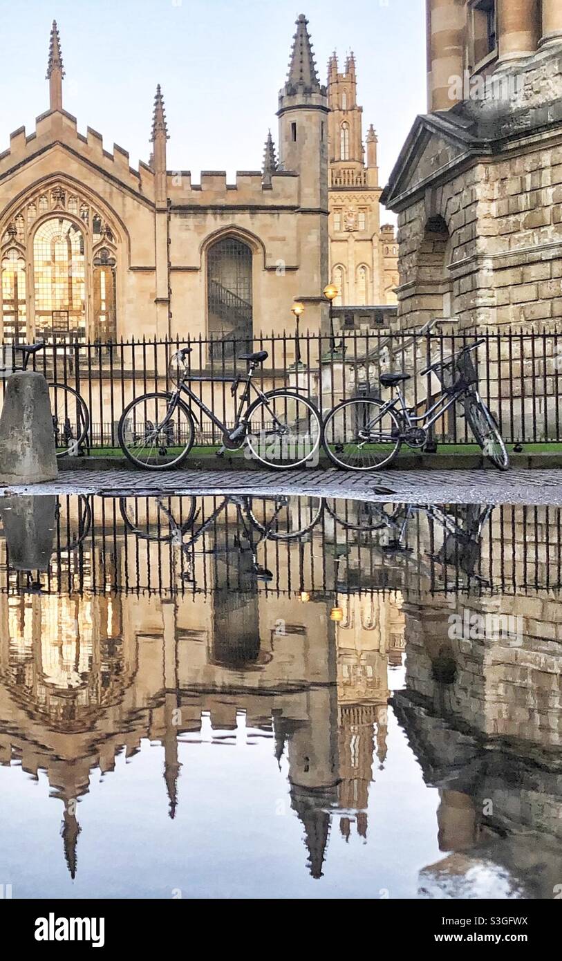 Ein Oxford College und Fahrräder spiegeln sich in einer regen Pfütze, Oxford, England Stockfoto