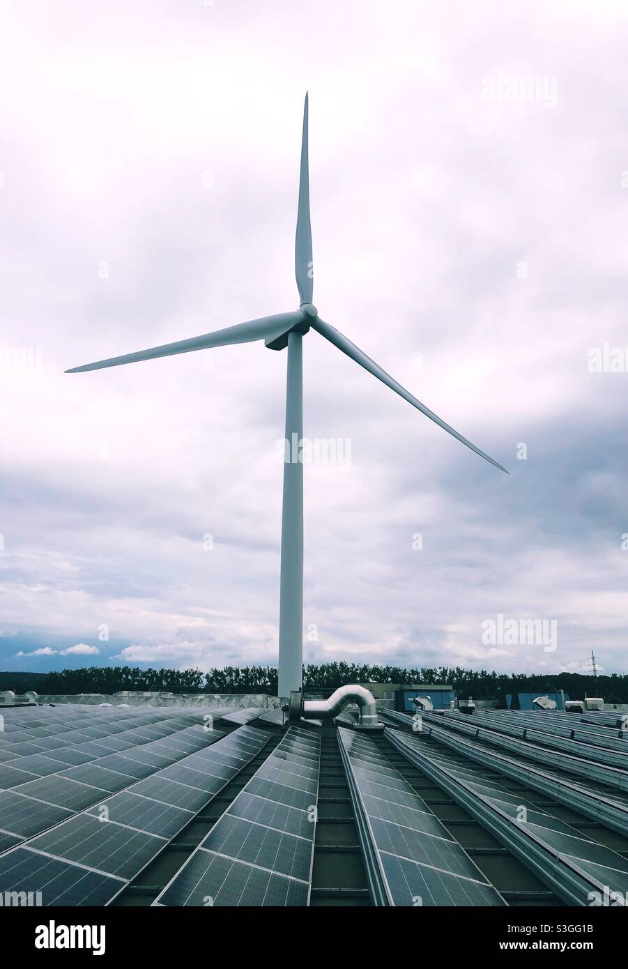 Windturbinen und Sonnenkollektoren auf einem Dach - Smartphone-aufgenommenes Stockfoto