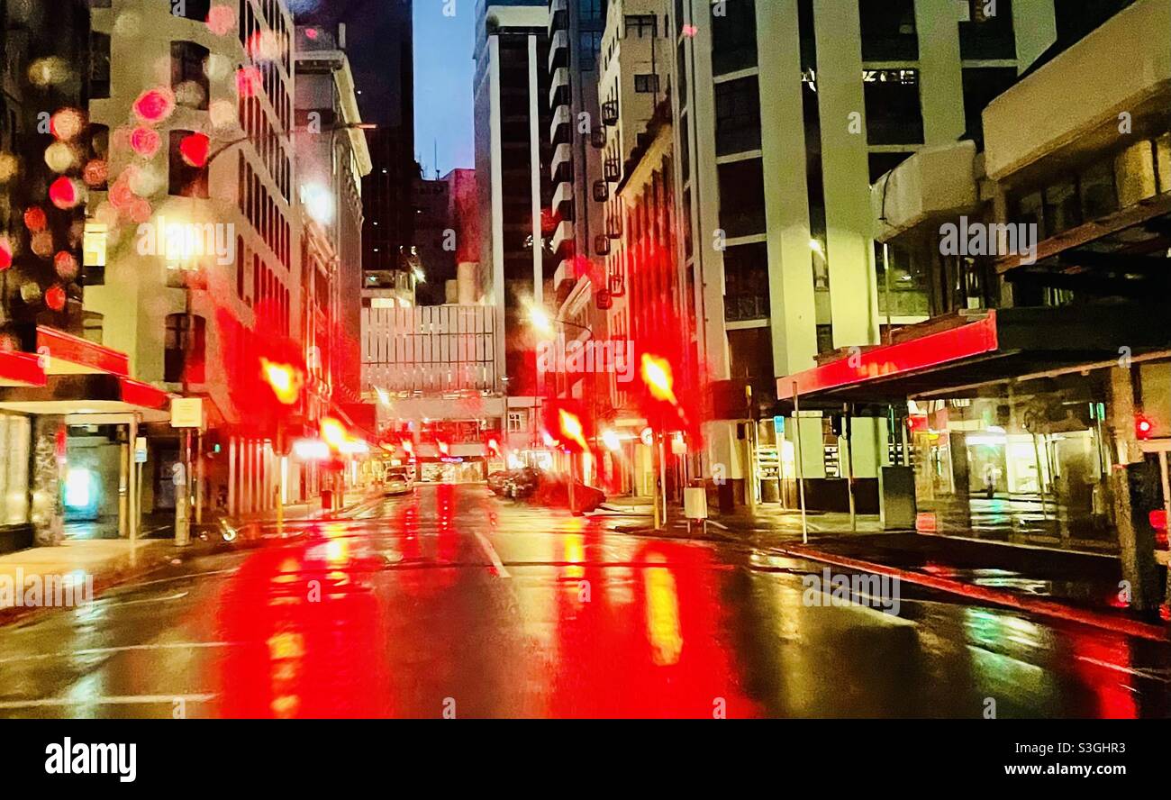 Am frühen Morgen in Wellington, Neuseeland, spiegeln sich Ampeln von der nassen Straße ab Stockfoto