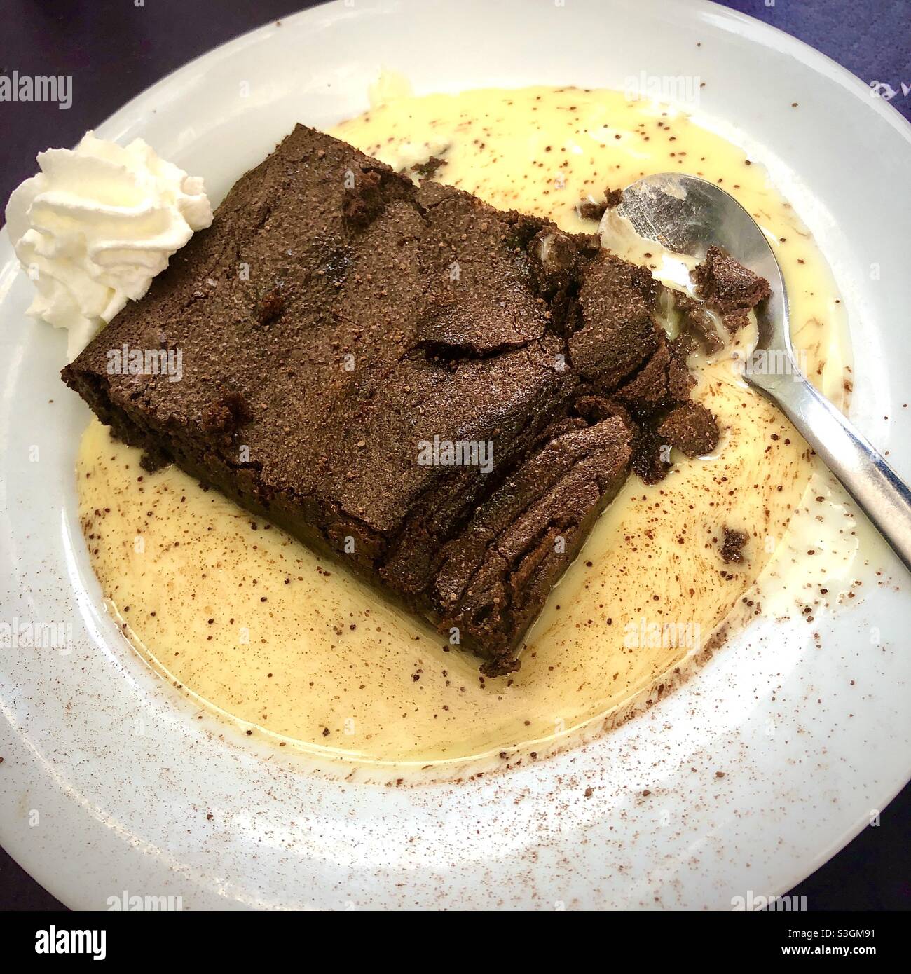 Schokoladen-Brownie-Dessert mit Pudding-Sauce. Stockfoto