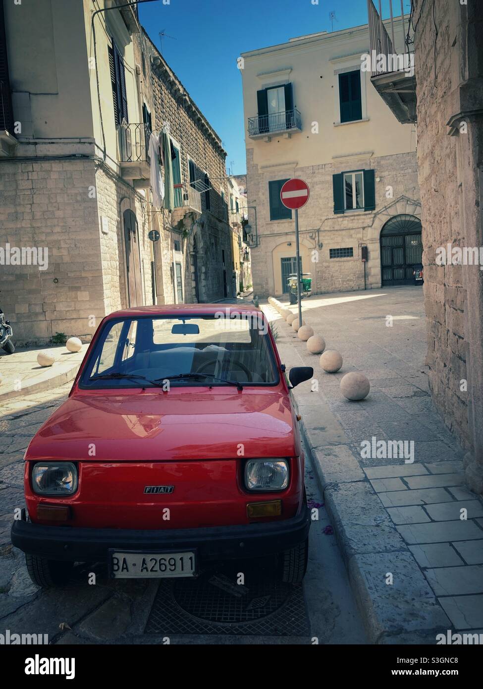 Ein rotes Auto in einer Straße in der apulischen Stadt Trani, Italien Stockfoto