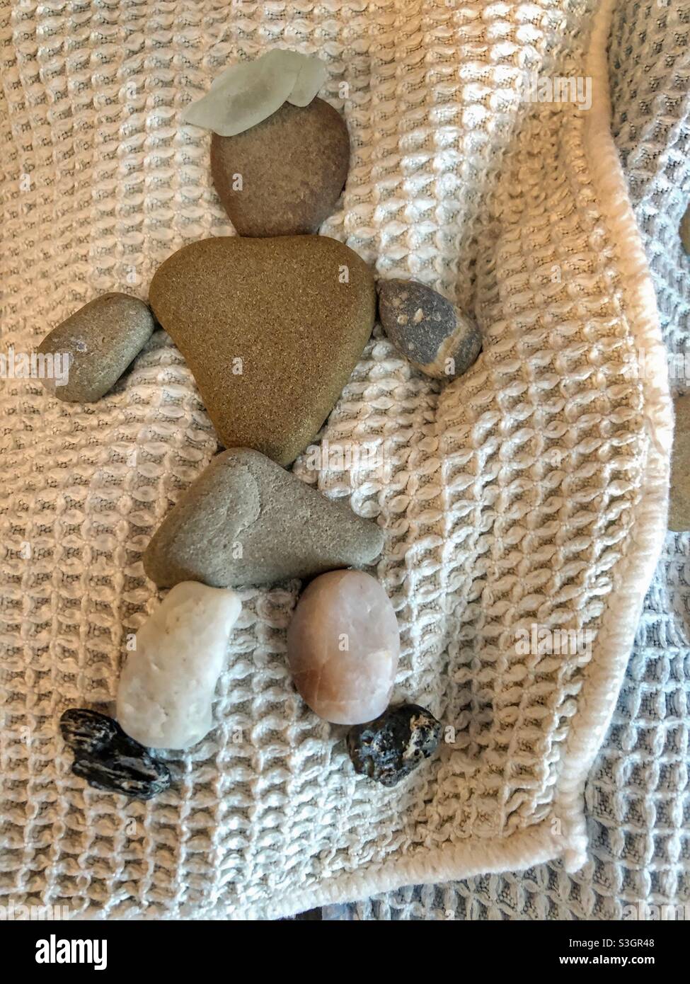 Eine Frau Steinkunstfigur auf einem hellen Stoffhintergrund. Stockfoto