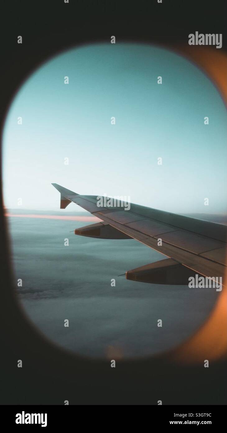 Flug irgendwo bei Sonnenuntergang in der Windows-Hütte mit Blick auf den Flugzeugflügel Stockfoto