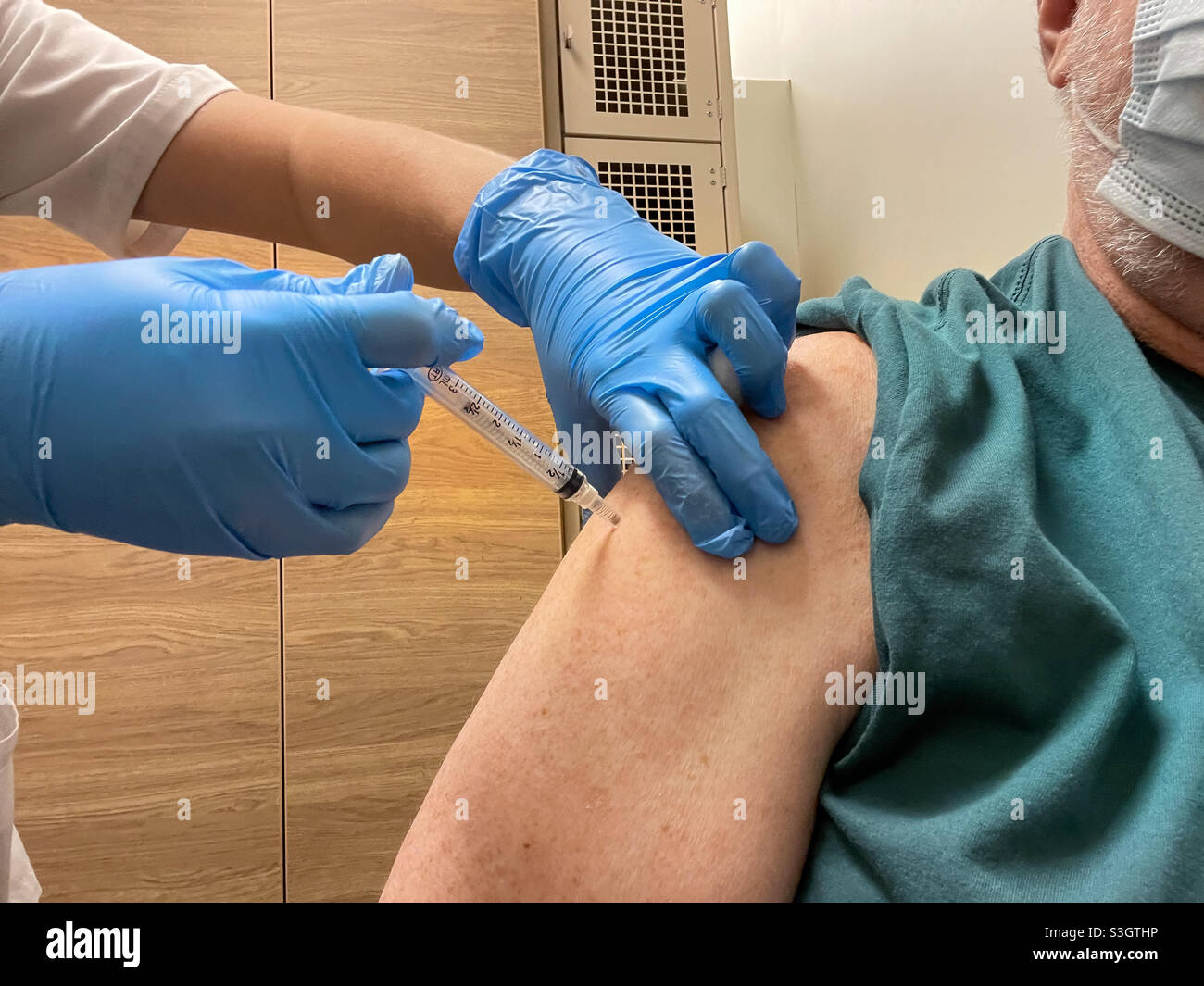 Senior erhält einen Impfstoff von Moderna COVID-19, der in einer Apotheke in Metro Atlanta geschossen wurde. (USA) - Smartphone-aufgenommenes Stockfoto