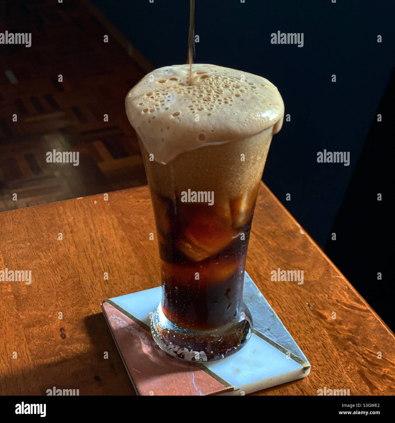 Stout Cocktail verschüttet über einem Glas. Stockfoto
