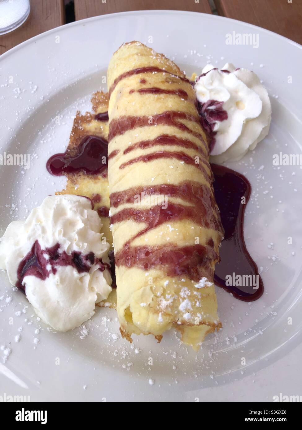 Ein köstliches Eis-Dessert Crepe mit Himbeersoße. - Smartphone-aufgenommenes Stockfoto