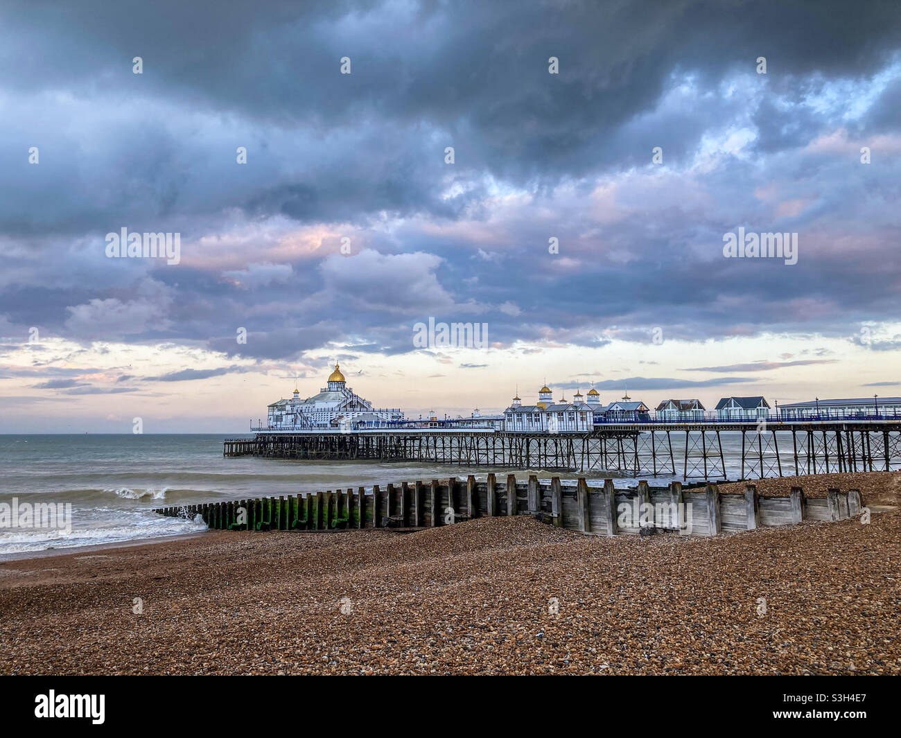 Eastbourne Pier in East Sussex an einem bewölkten Sommerabend kurz vor einem sintflutartigen Regenguss - Smartphone-aufgenommenes Stockfoto
