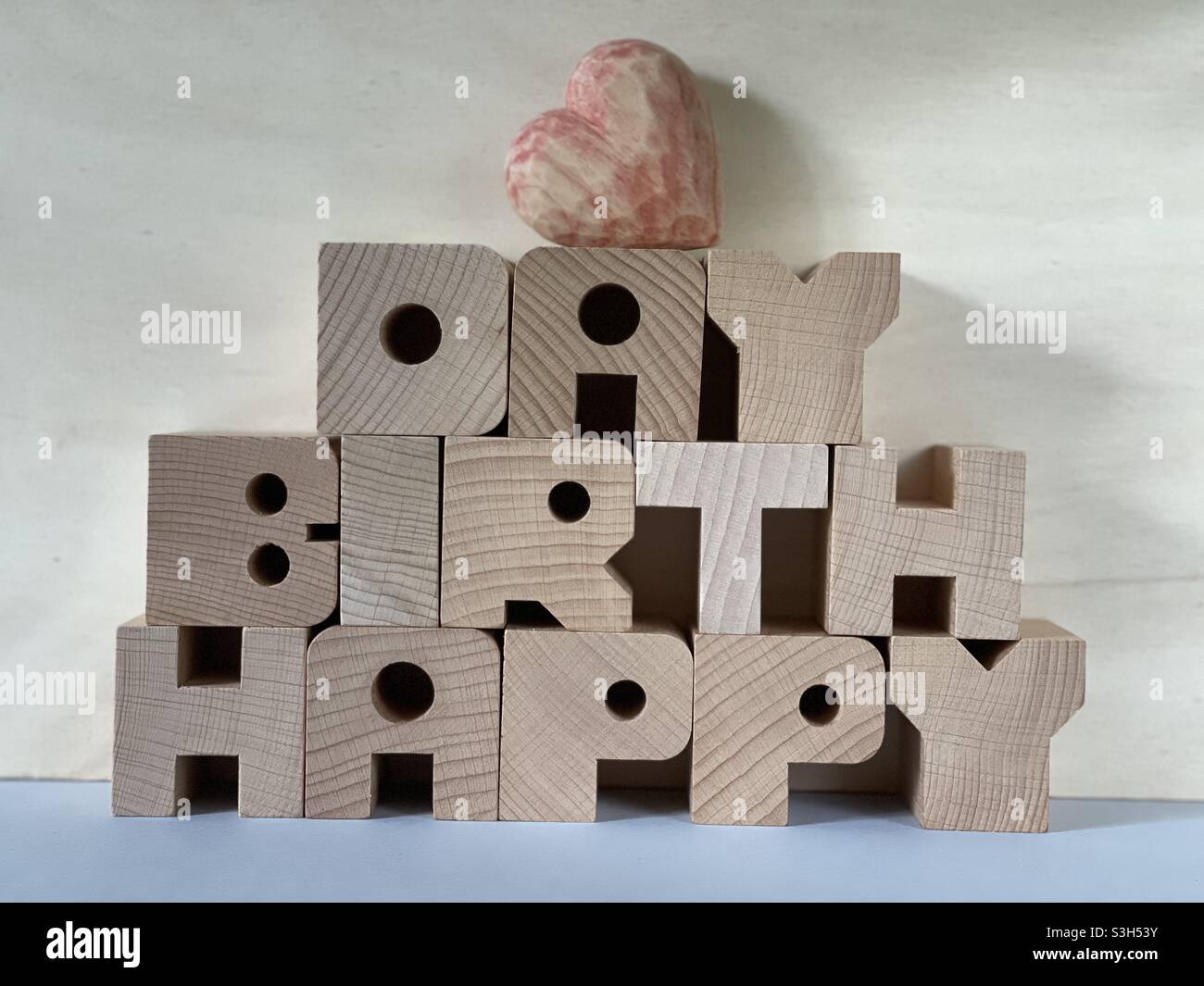 Happy Birthday Nachricht mit handgefertigten Holzbuchstaben und einem Holzherz Stockfoto