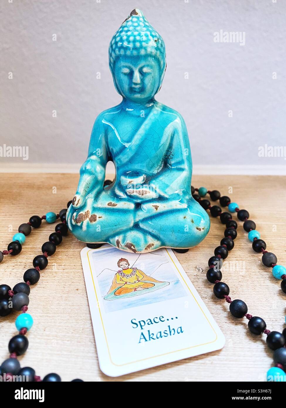 Eine Buddha-Figur mit einer Dharma-Karte mit den Aufschrift „Raum“ und „Akasha“. Stockfoto
