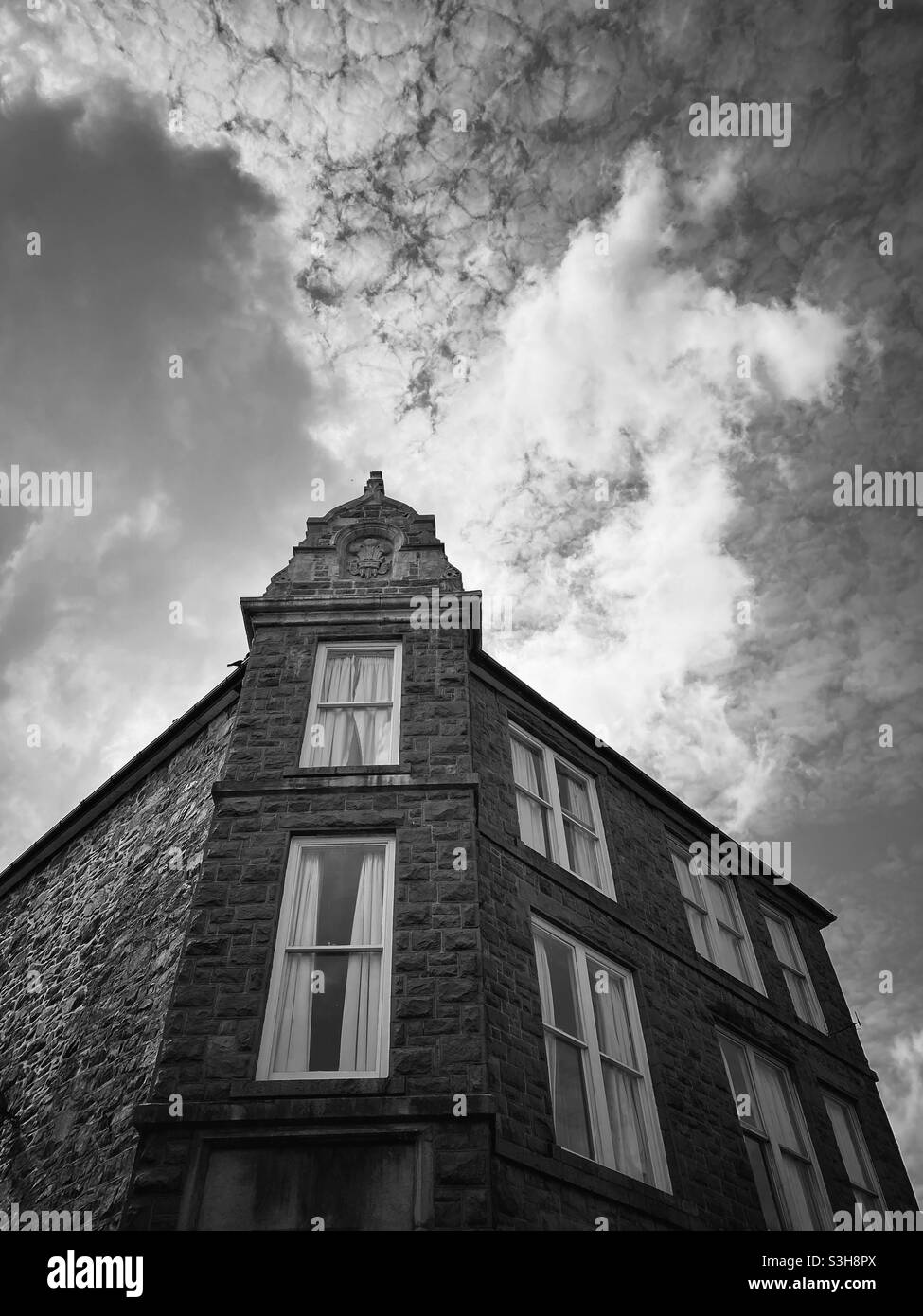 Ein Foto eines alten Gebäudes in einer alten walisischen Stadt, Dolgellau. Schwarz und Weiß mit einem ausdrucksstarken Himmel Stockfoto
