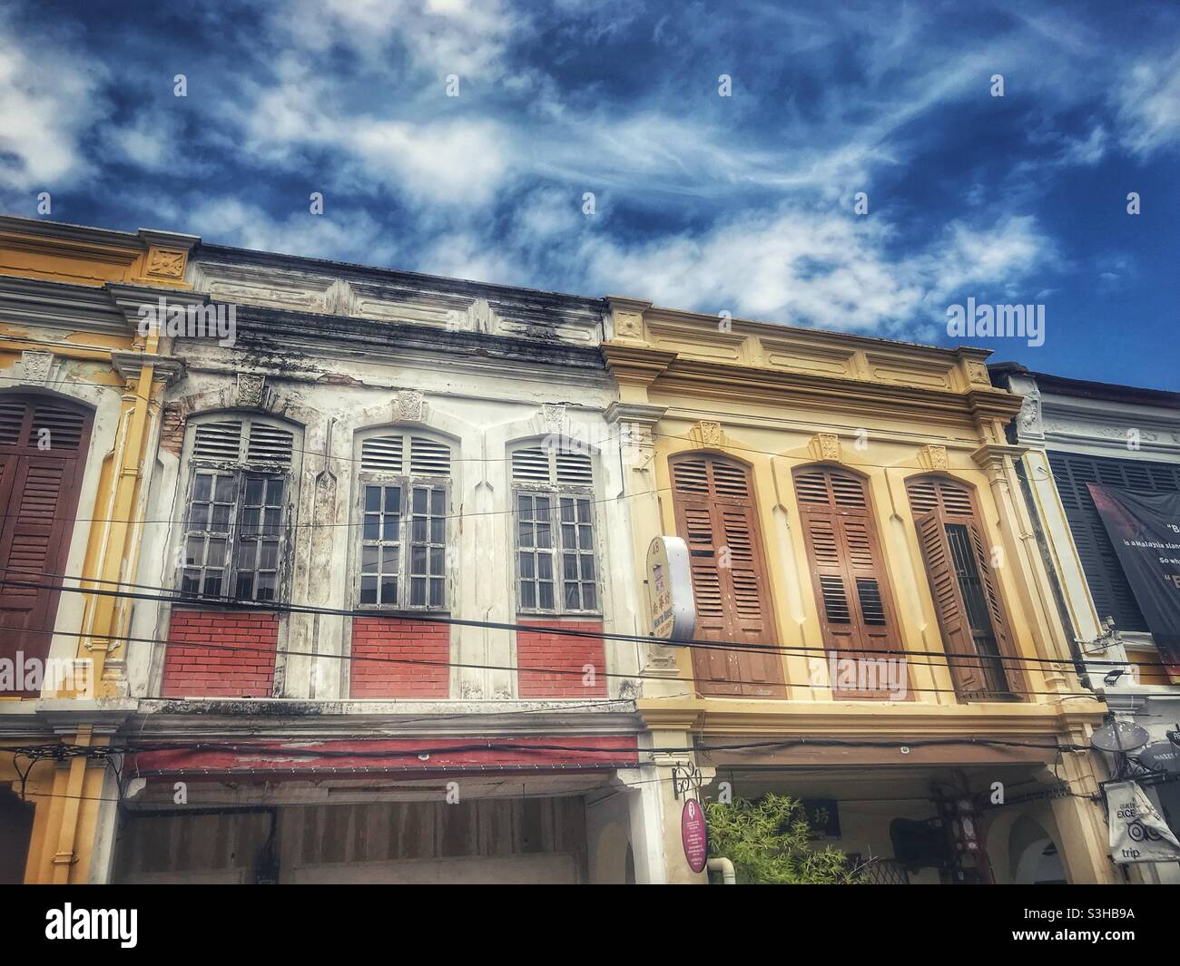 Fenster und Fensterläden im Obergeschoss der historischen Geschäftshäuser in George Town, Penang, Malaysia Stockfoto