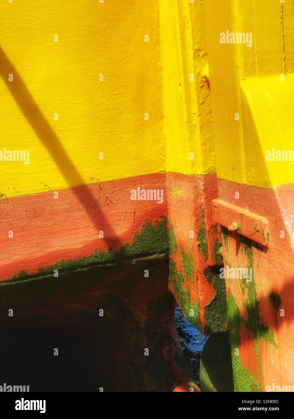 Sonnendurchflutete Details eines hell gestrichenen Bootes, das im August in einem kornischen Hafen festgemacht wurde. - Smartphone-aufgenommenes Stockfoto