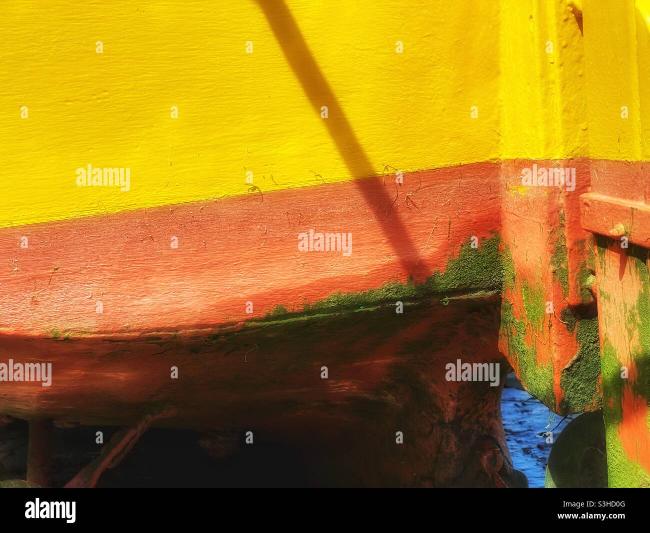 Sonnendurchflutete Details eines hell gestrichenen Bootes, das im August in einem kornischen Hafen festgemacht wurde. - Smartphone-aufgenommenes Stockfoto