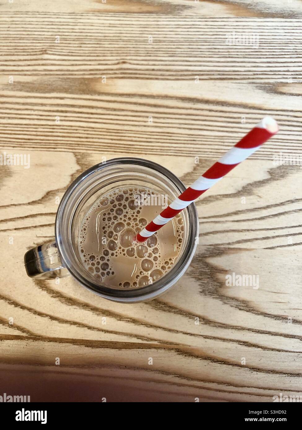 Draufsicht auf Milchshake mit gestreiftem Stroh Stockfoto