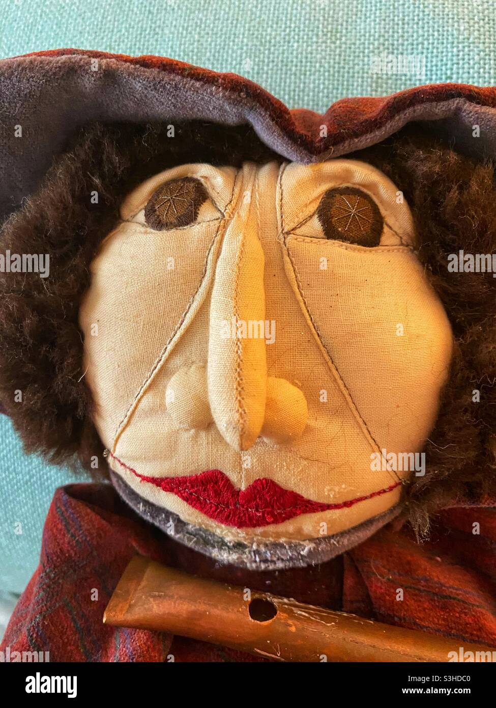 Gesicht der hausgemachten Puppe mit seiner Flöte Stockfoto
