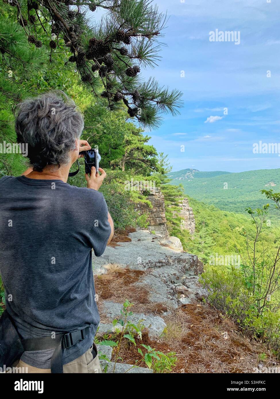 Mann fotografiert die Aussicht von Wanderungen in den Bergen, New York Stockfoto