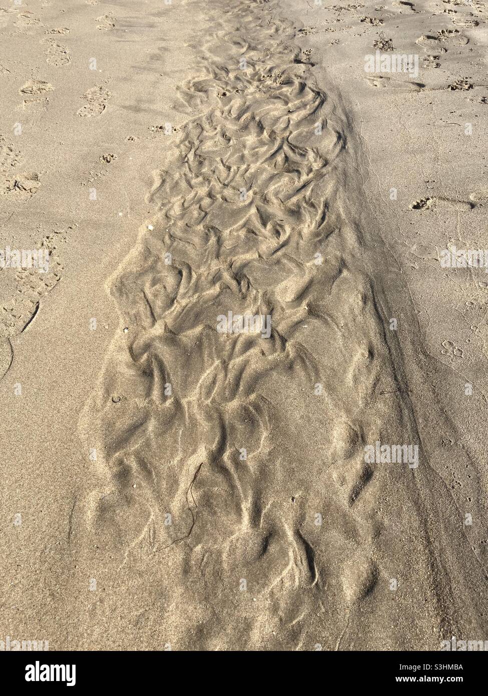 Muster, die durch Wind und Wellen im Sand am Strand entstehen Stockfoto