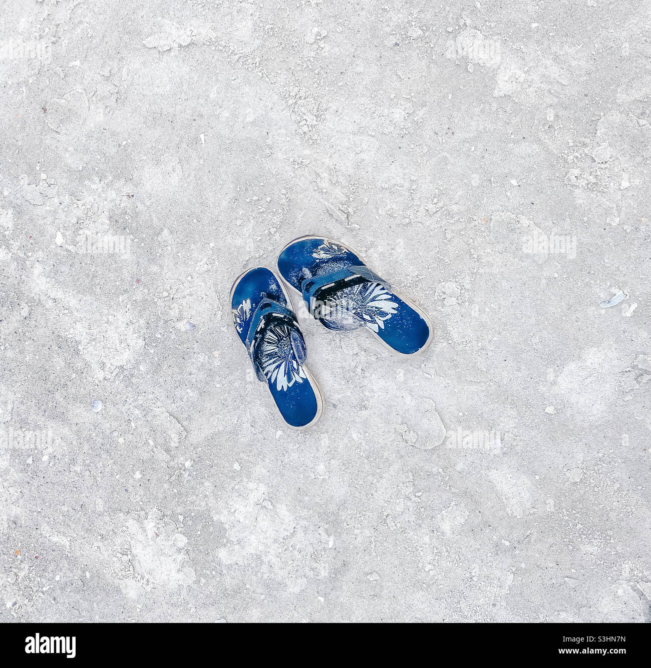 Sandflipflops am Strand Stockfoto