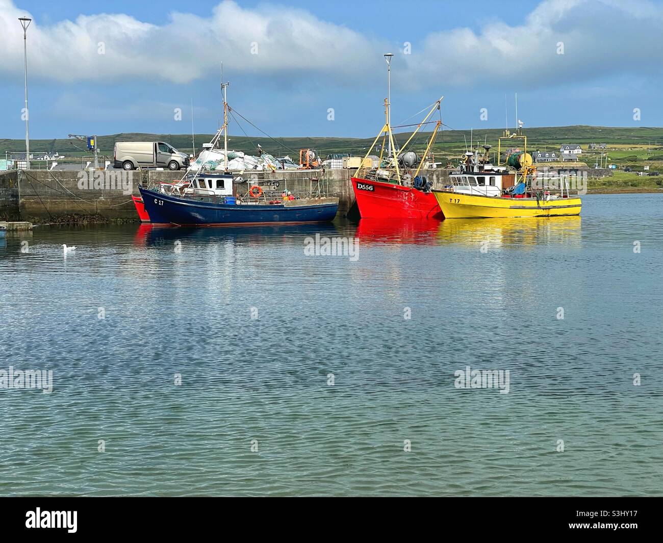 Port Magee Hafen mit festgetäuten Fischerbooten, Valentia Insel im Hintergrund, County Kerry, Irland, August. Stockfoto