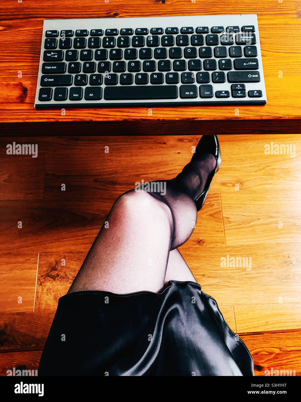 Frau mit gekreuzten Beinen, die von zu Hause aus arbeitet Stockfoto