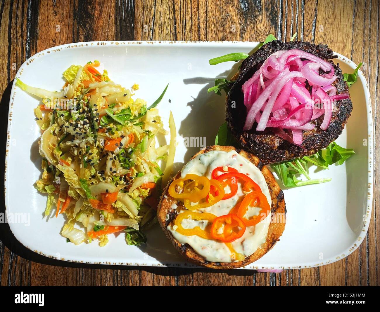 Ein veganer Wildreis-Burger mit einem Beilagensalat auf einem Teller. Stockfoto