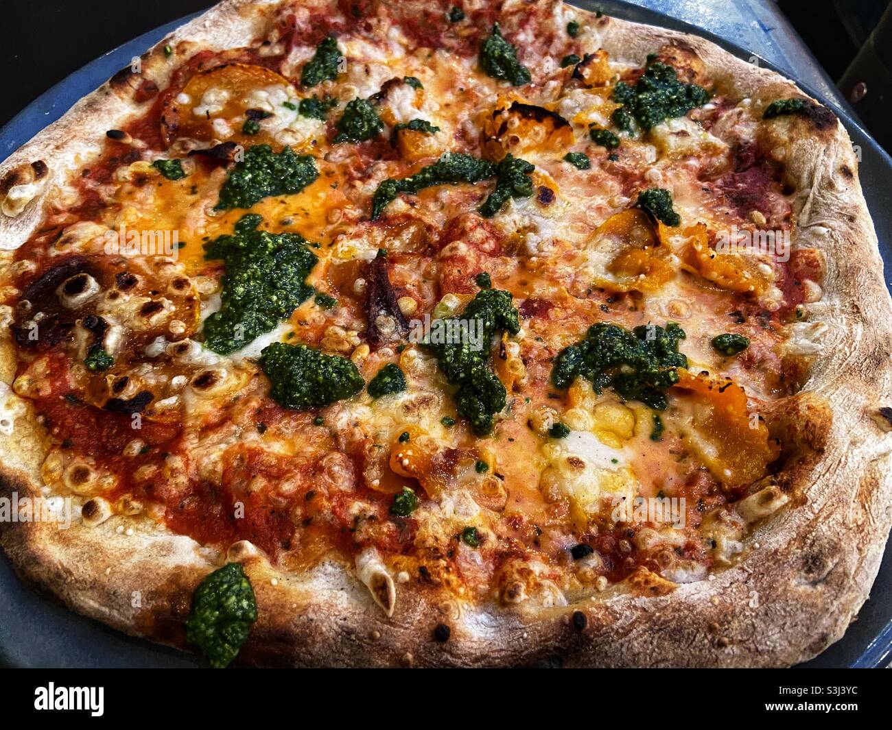 Vegetarische Pizza mit Pesto und Butternusskürbis. Stockfoto