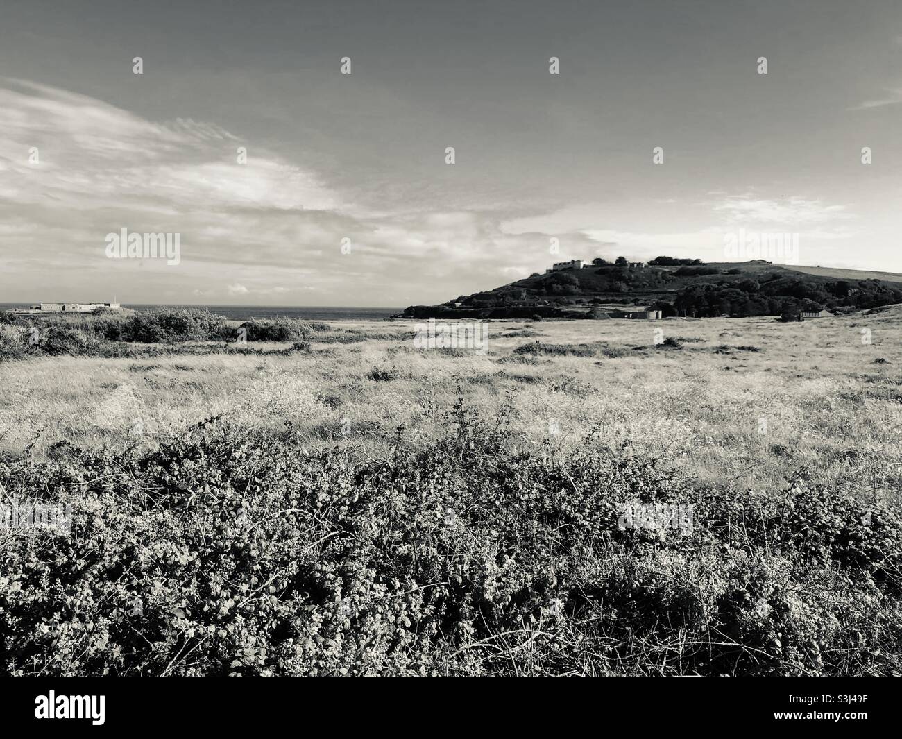 Stimmungsvolles Bild von Longis Common, Alderney, mit Blick auf das römische Fort von Nunnery auf dem russischen Friedhof. - Smartphone-aufgenommenes Stockfoto