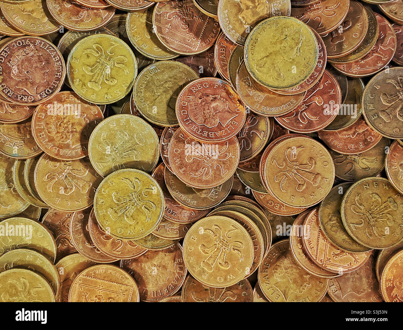 Eine Overhead-Ansicht (flaches Lay) einer Gruppe von neuen und alten britischen 2 Pence-Stücken. Alle sind gesetzliches Zahlungsmittel, wobei dies eine gemeinsame Szene in einem Arcade-Spiele - ein klassischer Spielautomat Blick. ©️ COLIN HOSKINS. - Smartphone-aufgenommenes Stockfoto