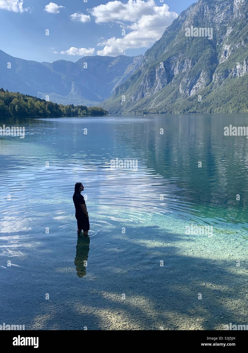 Mann, der allein im riesigen bohinjer See in Slowenien steht Stockfoto