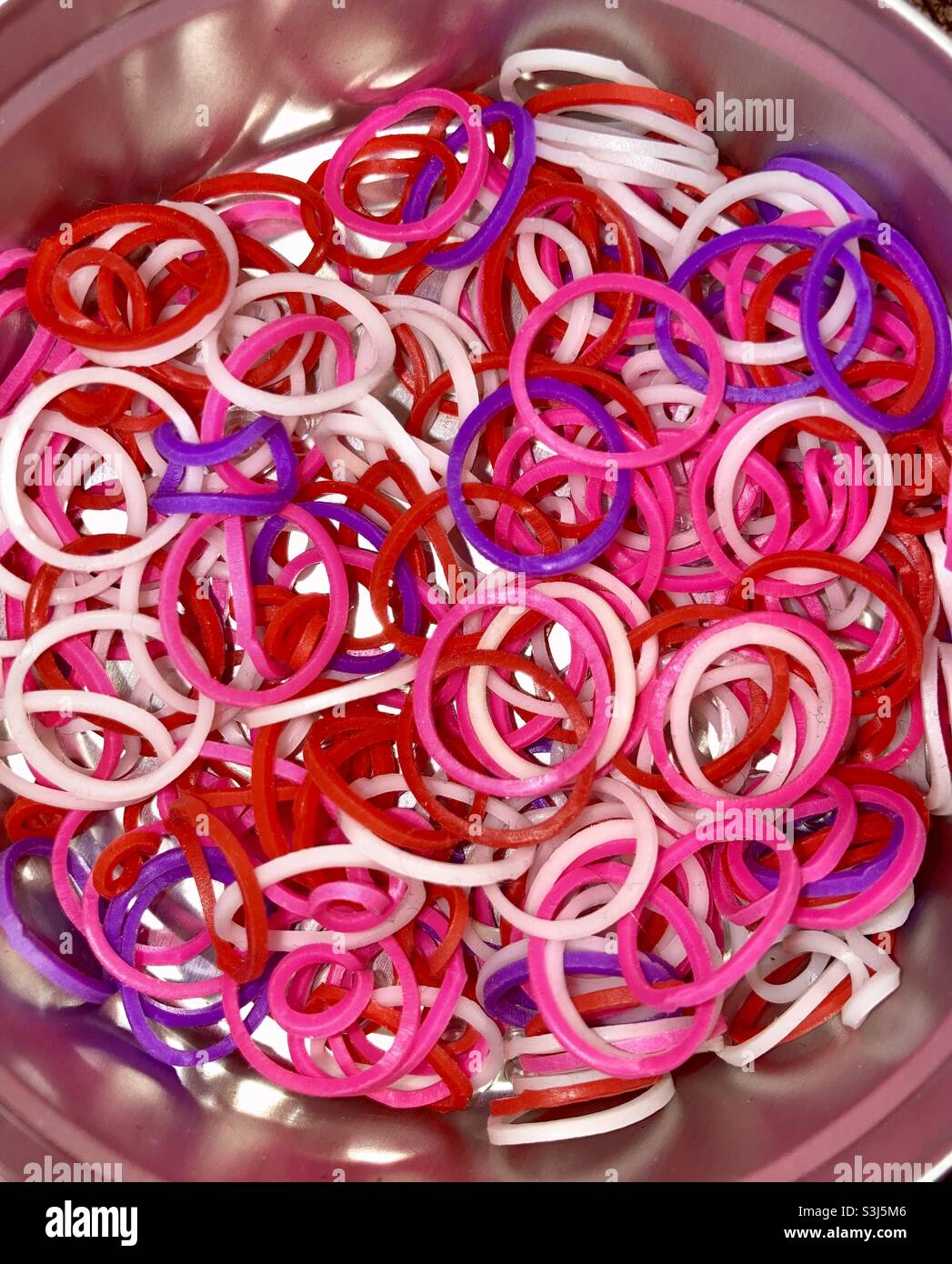 Farbige Gummiringe in einer Blechdose - Smartphone-aufgenommenes Stockfoto