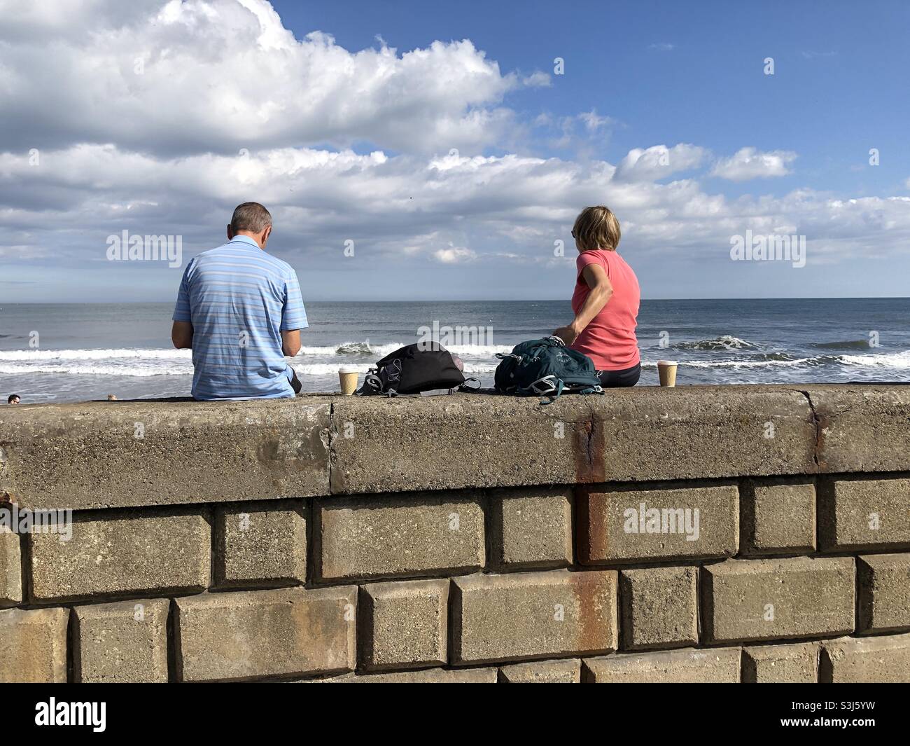 Pärchen, die eine Kaffeepause am Meer machen Stockfoto