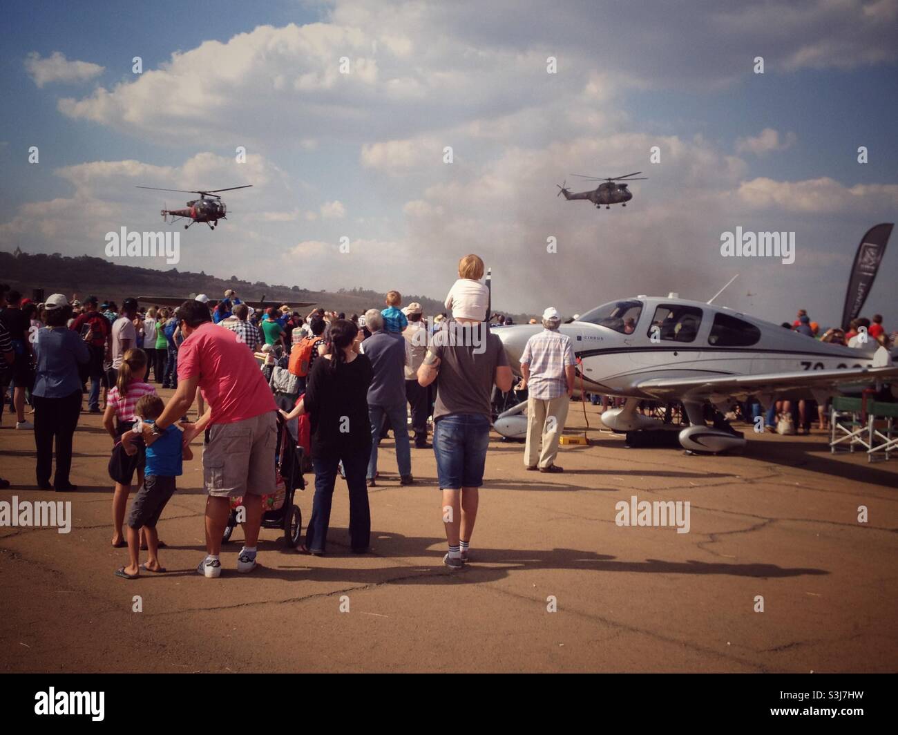 Zuschauer bei einer Flugshow in Südafrika beobachten Hubschrauber, die an Land kommen Stockfoto
