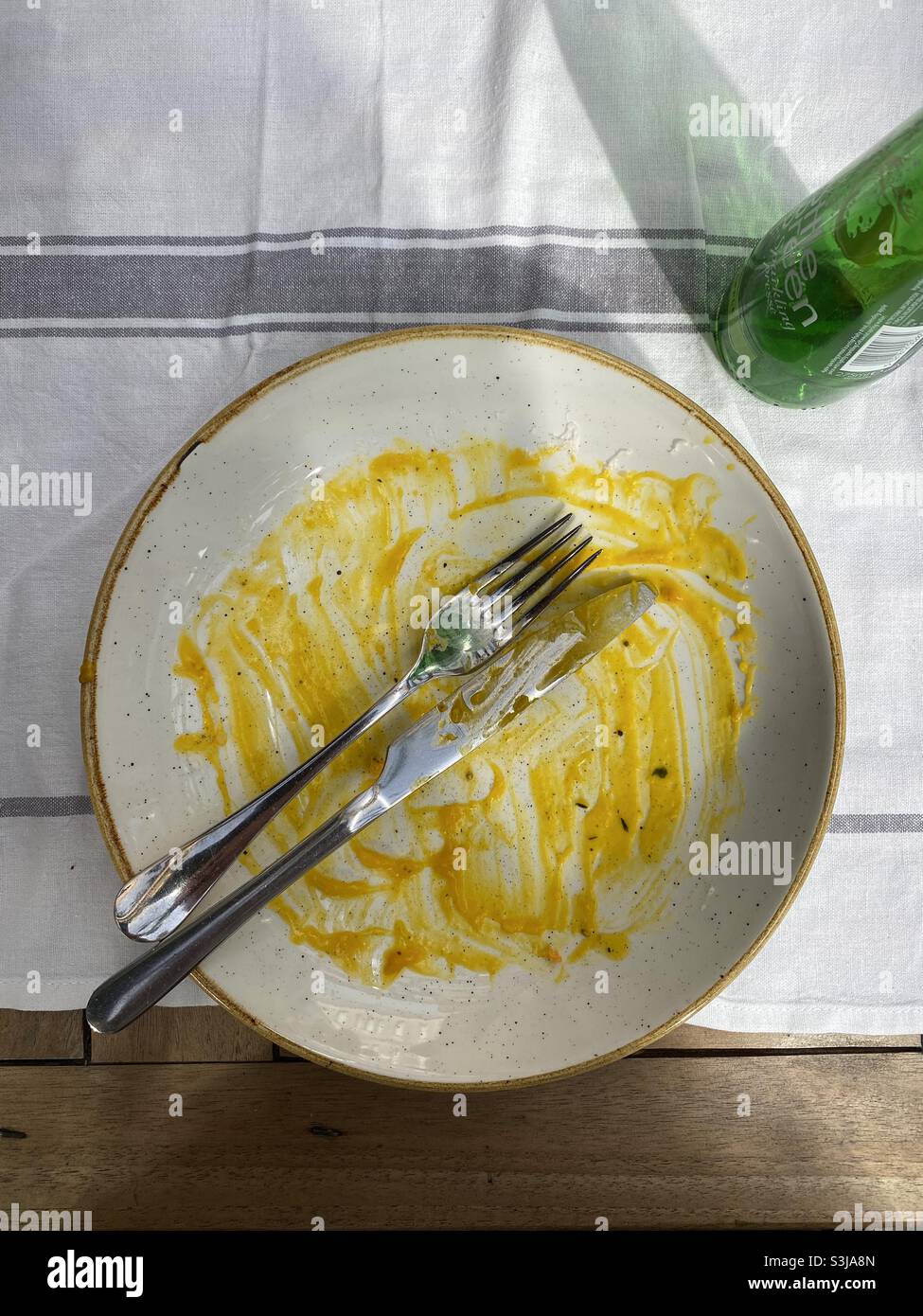 Ein leerer Teller - das Essen wird gegessen und das Essen wurde genossen. Es bleibt nur noch eine kleine Menge Butternussauce übrig. Foto ©️ COLIN HOSKINS. Stockfoto