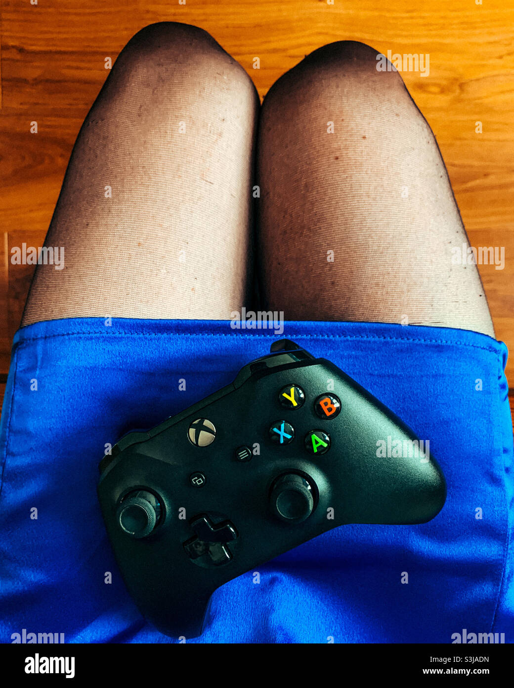 Xbox-Controller auf dem Schoß einer Frau Stockfoto